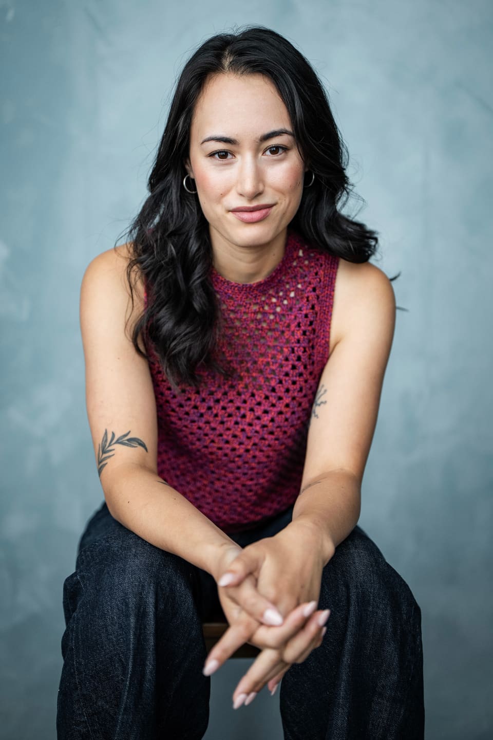 Sarah Suzuki seated against a blue backdrop